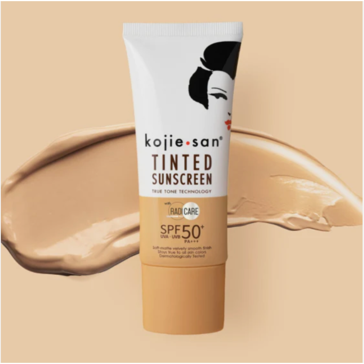 Tube of Kojie San Tinted Sunscreen with SPF50+ PA+++ indicated on the packaging, against a beige background with a swatch of the product's color.